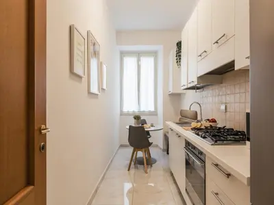 a kitchen with white cabinets and a stove top oven at The Best Rent – Bright two-bedrooms apartment in Testaccio area in Rome