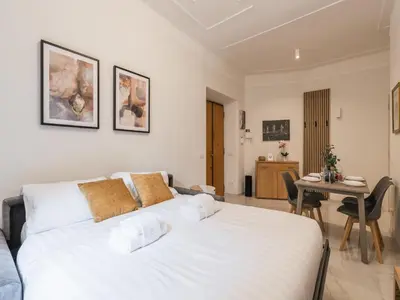 a white bed in a room with a table at The Best Rent – Bright two-bedrooms apartment in Testaccio area in Rome