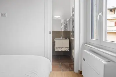 a bedroom with a bed and a bathroom with a sink at Sunny House Gianicolo in Rome
