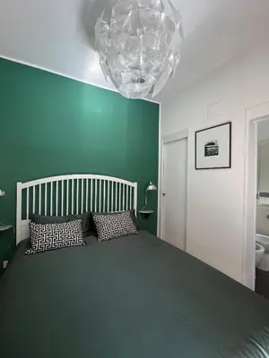 a bedroom with a large bed and a chandelier at Villa Borghese Green Apartment in Rome