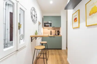 a kitchen with a counter and stools in a room at 2 BDR Navona Quintessential Charm in Rome