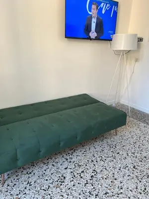 a green couch in a room with a tv at Luxury room Anelli center of Roma in Rome