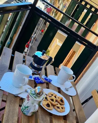 a table with two cups and cookies on a balcony at casa Aldini in Rome