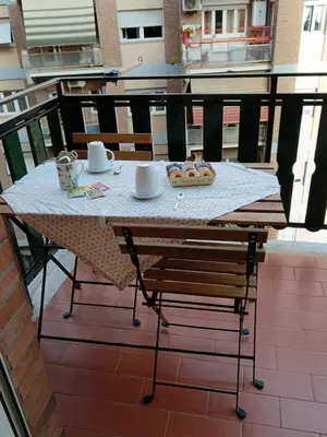 a table with a plate of food on a balcony at casa Aldini in Rome