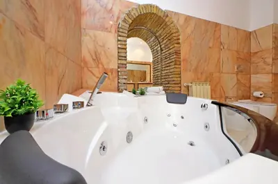 a large bathroom with a white tub in a room at 4BNB - Lungaretta Jacuzzi Apartment in Rome