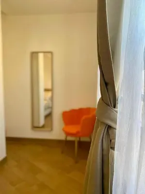 a room with a mirror and a chair and a curtain at Al Mamalo Rome Luxury Apartment in Rome