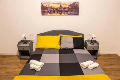 a bedroom with a bed with a yellow and black blanket at Locazioni Ostiense - Domus William in Rome