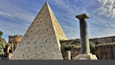 a tall tower next to a building with a pillar at Locazioni Ostiense - Domus William in Rome