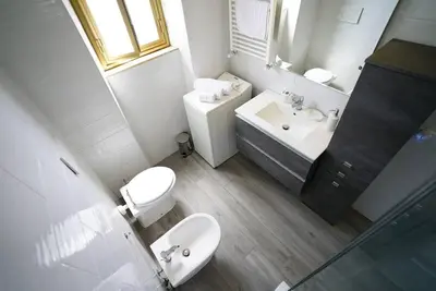 a white bathroom with a toilet and a sink at (9)Nine stops from the Colosseum in Rome