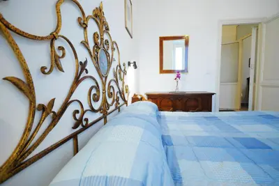 a bedroom with a bed with a blue blanket on it at Casa Anna a Roma in Rome
