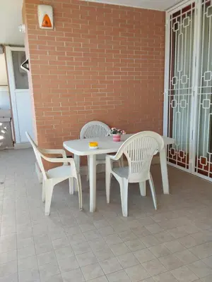 a white table and two chairs and a table and a brick wall at La casa di Gloria in Rome