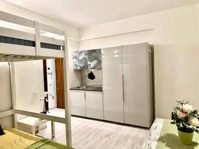 a bedroom with a bunk bed and a kitchen at Rome Apartment Marconi in Rome