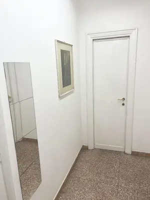 a white room with a mirror and a white door at Cuore di Marconi Apartment in Rome