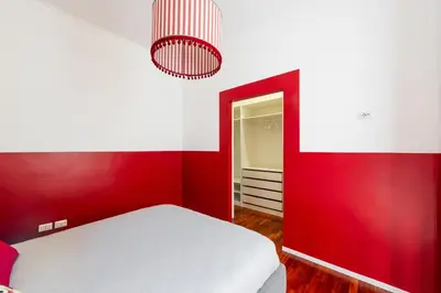 a red bedroom with a bed and a red wall at Mecenate Suite Colosseum in Rome