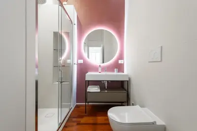 a bathroom with a toilet and a sink and a mirror at Mecenate Suite Colosseum in Rome
