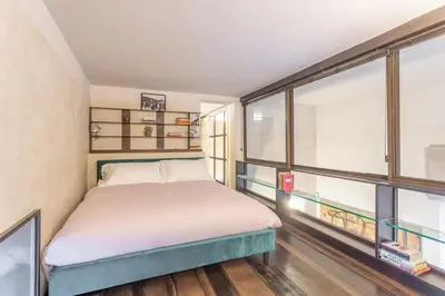 a bedroom with a bed and a large window at Iconic apartment with unique Colosseum view in Rome
