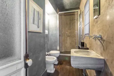 a bathroom with a sink and a toilet and a shower at Iconic apartment with unique Colosseum view in Rome