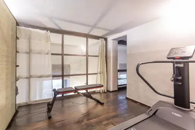 a room with a gym with a treadmill and a window at Iconic apartment with unique Colosseum view in Rome
