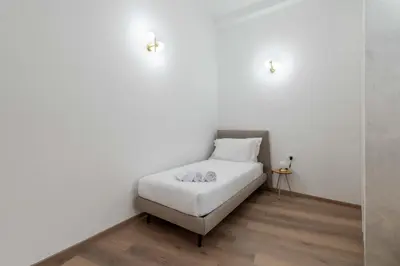 a bed in a room with a white wall at ELICAL Vatican Suites in Rome