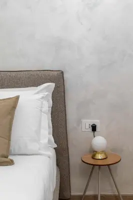 a bedroom with a bed and a table with a lamp at ELICAL Vatican Suites in Rome