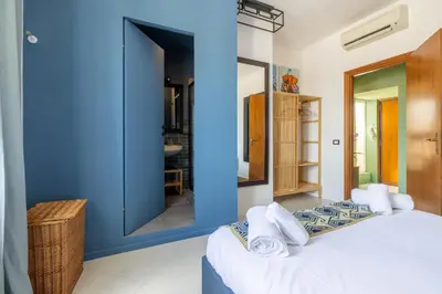 a blue room with a bed and a mirror at Spacious with terrace 3 bedroom, metroA Battistini in Rome
