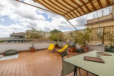 a patio with two tables and chairs on a balcony at Spacious with terrace 3 bedroom, metroA Battistini in Rome