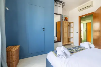 a blue room with a bed and a mirror at Spacious with terrace 3 bedroom, metroA Battistini in Rome