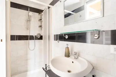 a white bathroom with a sink and a shower at Sanniti Loft San Lorenzo in Rome