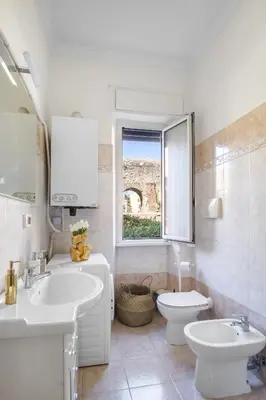 a bathroom with a sink and a toilet and a window at ArtStay AC Apt Near Metro, Fiumicino Airport in Rome