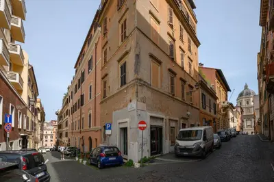 a building with cars parked on the side of a street at Quattro Cantoni Apartment Monti in Rome