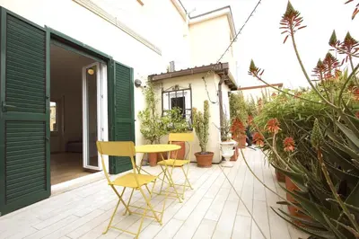 a patio with yellow chairs and a table and some plants at Statonia Terrace Penthouse in Rome