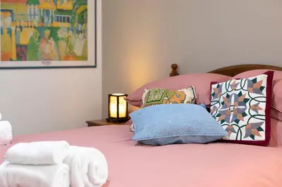 a bedroom with a pink bed with pillows at Alchimia Friends and Family 3 bedrooms 3 bathrooms in Rome