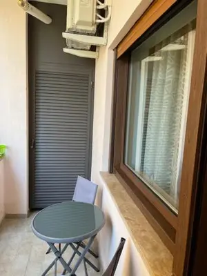 a table and chair in a balcony with a window at Casa Dalia in Rome