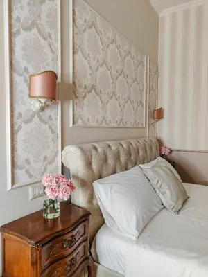 a bedroom with a bed and a table with flowers on it at Maison Bonheur in Rome