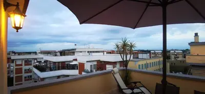 a balcony with two chairs and an umbrella at Cosy penthouse loft with view in Rome