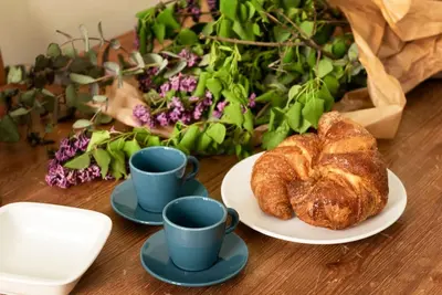 a table with two cups of coffee and a plate of croissants at Luxury Blu Rome in Rome