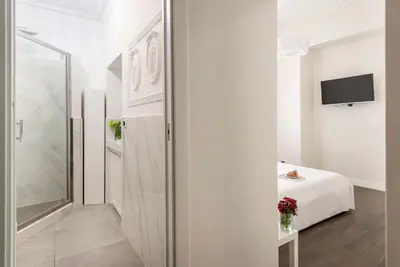 a white room with a bed and a television at Luxury Blu Rome in Rome