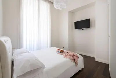 a bedroom with a white bed and a flat screen tv at Luxury Blu Rome in Rome