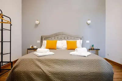 a bedroom with a large bed with yellow and white pillows at Maison Vaticano in Rome