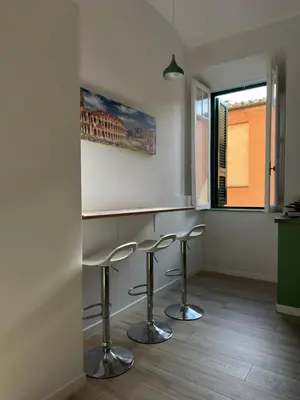 a kitchen with two bar stools and a window at Colosseo House in Rome