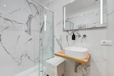 a white bathroom with a sink and a shower at LISA SUITE in Rome