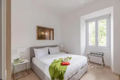 a bedroom with a white bed with a green blanket at iFlat Vatican 2 Bedroom Design Apartment in Rome