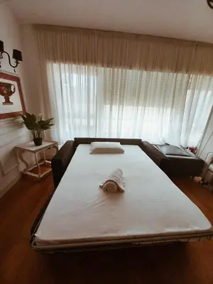 a large bed in a room with a large window at Qg Tacito 90 in Rome