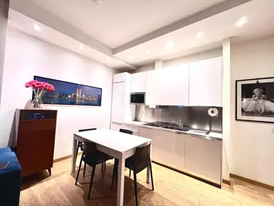 a kitchen with a white table and a table and chairs at Qg Tacito 90 in Rome