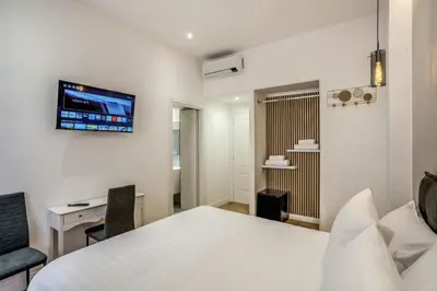 a bedroom with a bed and a desk and a tv on the wall at Vatican Eagle in Rome