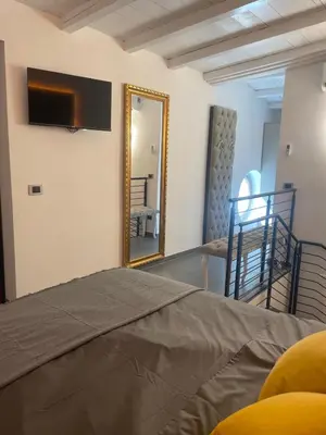 a bedroom with a bed and a mirror at JOIVY Exclusive 2-Bedroom Villa with Private Garden - 5 minutes from the Colosseum in Rome