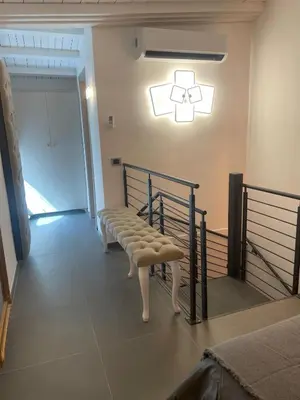 a white bench sitting in a room with a light at JOIVY Exclusive 2-Bedroom Villa with Private Garden - 5 minutes from the Colosseum in Rome