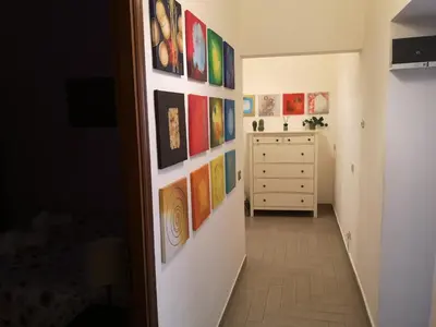 a hallway with paintings on the wall and a dresser at Gio's home in Rome