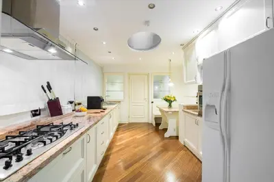 a kitchen with white cabinets and a stove top oven at 47Luxury Suites - Colosseo in Rome