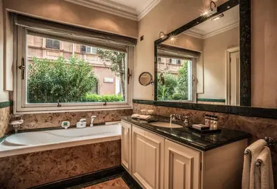 a bathroom with a tub and a sink and a mirror at 47Luxury Suites - Colosseo in Rome